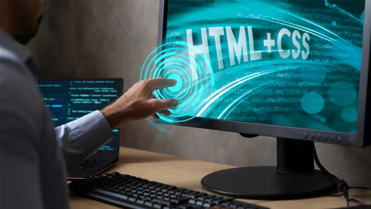 Developer interacting with a screen displaying HTML and CSS code, representing the technical foundation of website redesign services in Chicago.