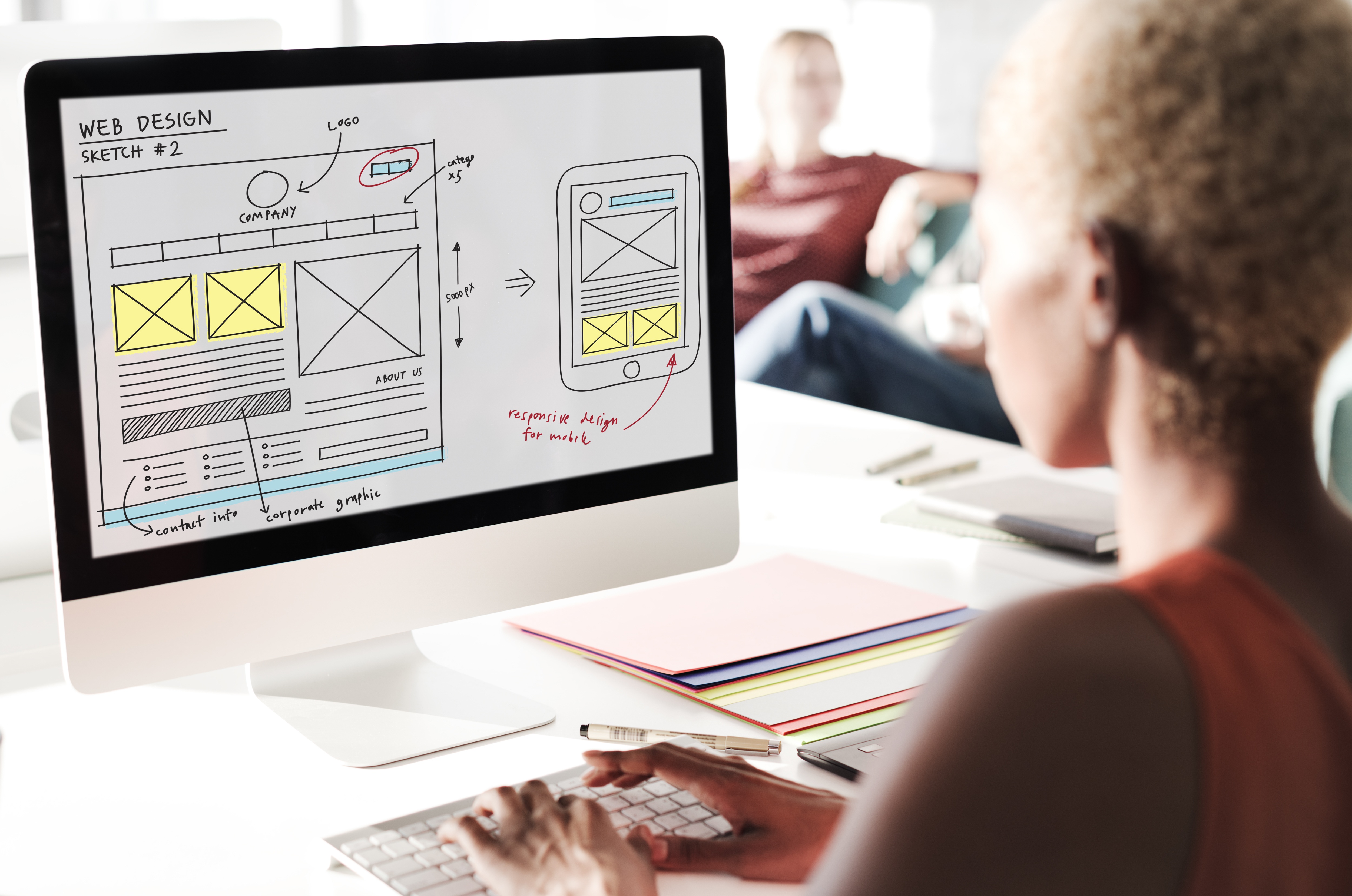 A designer planning a responsive website layout on a computer screen in a modern office, representing professional web design in Chicago